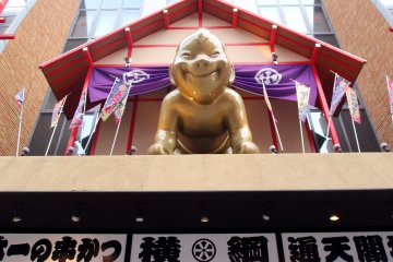 Billiken, a God of Good Luck or Happiness smiles down at me.