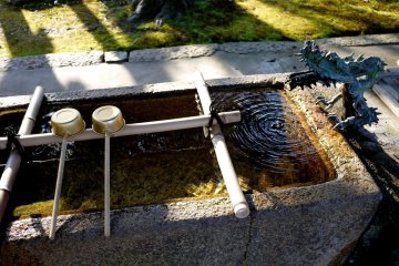 <p>A small dragon presides over the water basin for purifying hands</p>