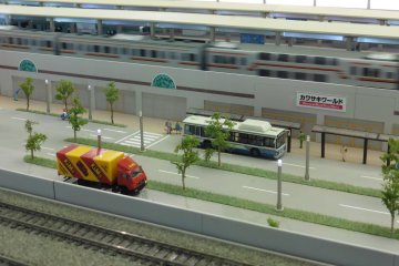 <p>A train passing by Kawasaki World station</p>