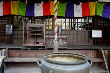 <p>Multi-colored curtains hanging above the temple doors</p>