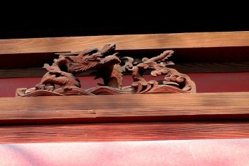 <p>A carved wooden dragon on the gate</p>