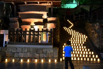 <p>A boy looks on at the illuminated deer figure next to the shrine.</p>