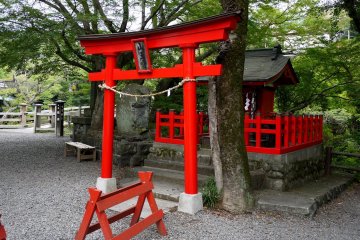 <p>A small red shrine stands on one side of the bridge</p>