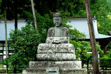 <p>A statue of Buddha meditating in the garden</p>