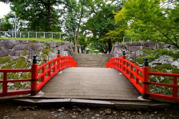 <p>The red painted bridge that leads to where the main grounds of Morioka Castle once stood</p>