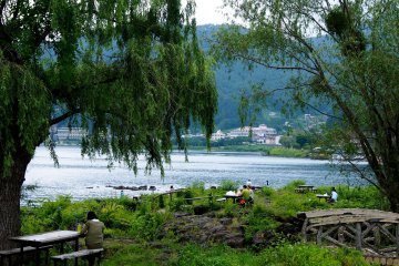 <p>At the slightest hint of sunshine, the locals and tourists sit by the picturesque lakeside</p>