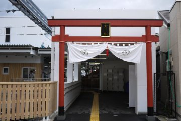 <p>A red tori stands at the entrance of Fujikyuko Railway Station, and there are lockers available</p>