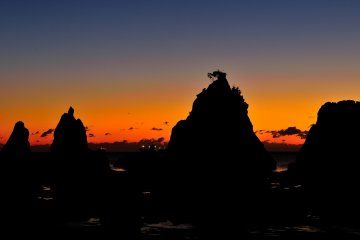 <p>Notice the light coming from ships far out at sea over the rocks</p>