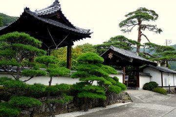 <p>The bell tower stands beside a gate</p>