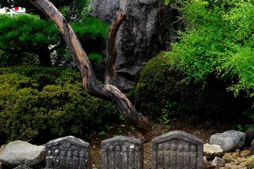 <p>Arrangement with huge rock and small statues</p>