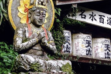 <p>Ini adalah arca Dinichi Nyorai, tokoh sentral dari Mikkyo atau Buddhisme esoterik. Arca ini dapat ditemukan dalam posisi bersila di atas kelopak lotus dengan tangan yang membentuk mudra, atau gestur meditasi.</p>