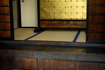 <p>A gold screen standing just inside the temple reflects the light</p>