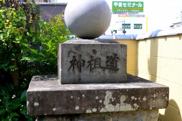 <p>Lichen grows on an old-looking plinth bearing a new-looking ball</p>