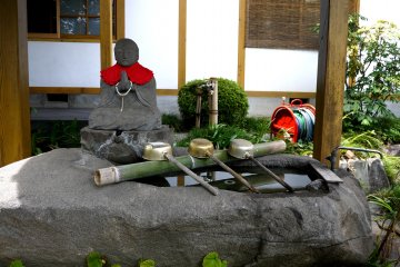 <p>Praying statue beside the water basin</p>