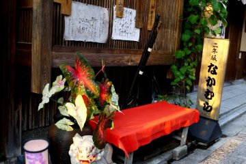<p>A red covered bench outside a restaurant where customers can wait for a table</p>