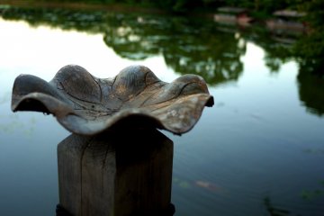 <p>A carved wooden bowl like a lotus leaf at the end of the pier</p>