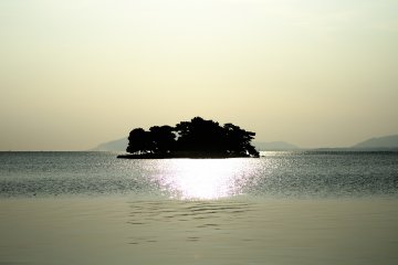 <p>Le soleil se couche &agrave; l'ouest mais il reste encore un peu de temps avant le coucher de soleil. L'&icirc;le Yomegashima est alors sublim&eacute;e par une lueur argent&eacute;e</p>
