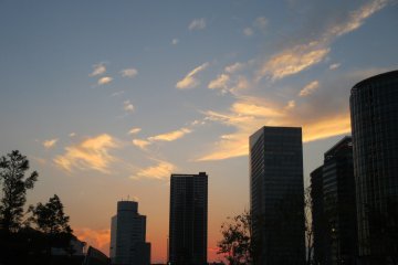 Langit terlihat lebih hidup di antara bangunan dan matahari terbenam
