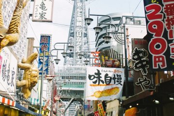 <p>Ramainya pertokoan di Shinsekai dengan latar belakang Menara Tsutenkaku</p>