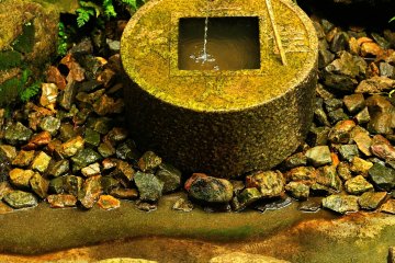 <p>On the old coin shaped 'Tsukubai (water purification basin)', a Zen maxim is carved</p>