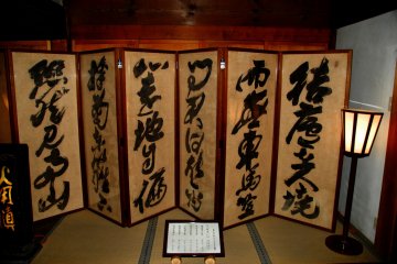 <p>Folding screen at the doorway of the Kuri building. A Chinese poem was calligraphed by Teranishi Kenzan on it</p>