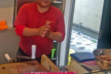 <p>One of two cooks preparing fresh octopus crackers</p>