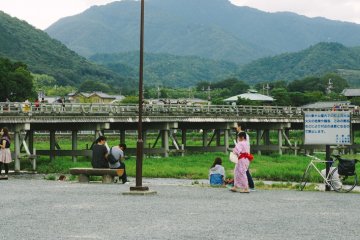 <p>By the Katsura River, the local tourists are relaxing and enjoying the afternoon in Summer. Togetsukyo&nbsp;in the background is one of famous bridges in Arashiyama</p>