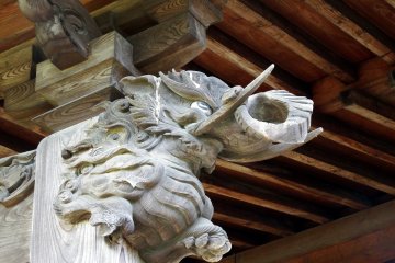 <p>Wooden guardian dog on a temple pillar</p>