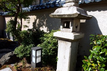 <p>Stone lantern standing alone in front of Three Sisters Shrine</p>