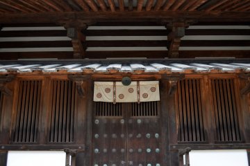 A wooden door with beautiful patterns. This is one of the entrances of the temple's five-story pagoda