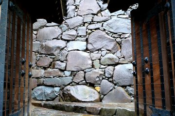 <p>Stone walls framed by a gate</p>