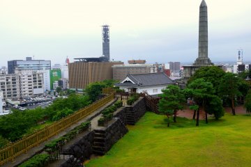 <p>A tall monument stands in the park near the reconstructed Yamanote Gomon gate</p>