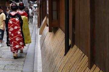 <p>Deux maiko (v&eacute;ritables ou non) se promenant le long de la rue</p>