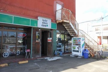 <p>Lucky Oldies Show is inside this large brick building with a small sign over the entrance</p>