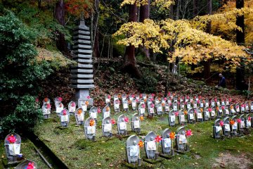 <p>A stone pagoda overlooks a clearing full of Ojizo</p>