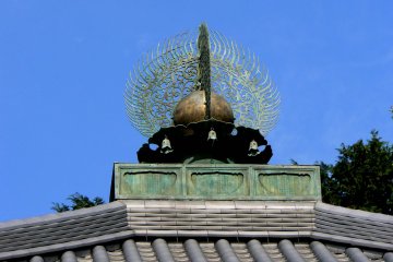 <p>Intricate roof ornament against a clear blue sky</p>