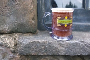 <p>ZONE 1 > HOGSMEADE VILLAGE : เอาความอร่อยเย็นๆ มาเสิร์ฟกันถึงที่ ซึ่ง BUTTERBEER นี้เป็นสุดยอดเครื่องดื่มแห่งเมืองเวทมนตร์ซึ่งเป็นที่โปรดปราณของคนทุกคน ขึ้นชื่อว่าเป็นเบียร์นั้นแต่ว่าจริงๆ เครื่องดื่มนี้ไม่มีแอลกอฮอลล์ผสมอยู่แต่อย่างใด ฉะนั้นเด็กดื่มได้ผุ้ใหญ่ดื่มดี รสชาตินั้นคล้ายกับน้ำอัดลมหวาน (รสรูทเบียร์) ที่ผสมกับฟองเนยอันหวานมันนุ่มนวล ... แล้วถ้าหากใครอยากได้แก้วที่ระลึกกล้บบ้านก็สั่งแบบนี้ได้เลย (ราคาเครื่องดื่ม 600 เยน / ราคาแก้ว 500 เยน)&nbsp;</p>
