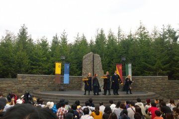 <p>ZONE 1 > HOGSMEADE VILLAGE : ที่ท้ายหมู่บ้านนั้นจะมีเวทีการแสดงซึ่งจะมีการแสดงที่น่าสนใจหลายชุดเวียนมาให้ชมกันตลอดทั้งวัน กิจกรรมนี้เป็นที่โปรดปราณของผู้มาเยือนมากทีเดียว และนี่ก็คือหนึ่งในการแสดงยอดนิยมประจำหมู่บ้าน HOGSMEADE VILLAGE นั่นก็คือ&nbsp;The Frog Choir กลุ่มนักร้องประสานเสียงแห่งโรงเรียน HOGWARTS นั่นเอง ซึ่งการแสดงนีั้ยังมีการนำกบจำลองประกอบเทคนิคที่มาร่วมร้องได้อย่างไพเราะเหมือนจริงอีกด้วย</p>