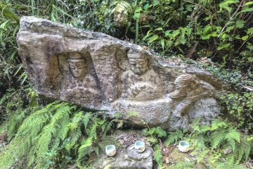 <p>This piece is unique in that it's separate from the main rock face. Perhaps at one time it was a part of it. If so, thankfully it sits here firmly and, as you can see, offerings are still being made out of respect.</p>