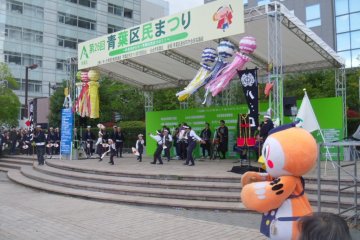 <p>A suzume odori group dance, supported by the dance's mascot, Suzunosuke</p>