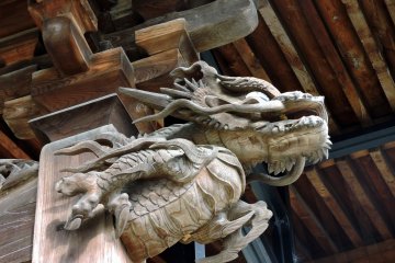 <p>Wooden carving of a guardian dragon on the temple pillar</p>
