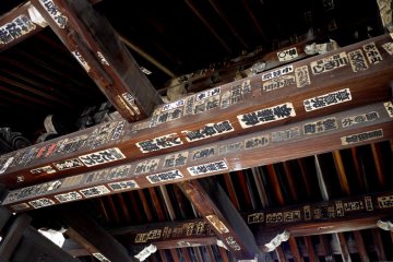 <p>Pilgrim stickers on the wooden roof beams of the gate</p>