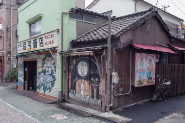 <p>These stores really stand 'cheek-to-cheek', with each store often displaying unrelated murals</p>