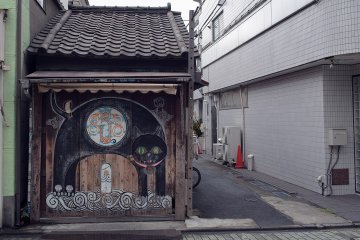 <p>A detailed photograph of the store with the outstretched cat painted on the front</p>