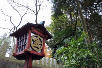 <p>Red wooden lantern on the shrine grounds</p>
