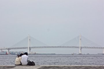 Sepasang kekasih menikmati pemandangan Jembatan Teluk Yokohama