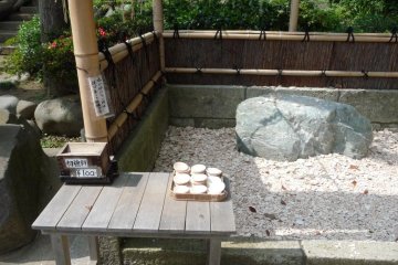 This is at the Kuzuharaoka Shrine.  There is a little area where you can pay 100 yen for a ceramic plate which you can throw and break against a rock to chase away the negative and malignant forces in your life.