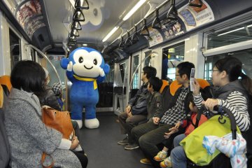 <p>Maskot Kota Chiba menghibur penumpang yang berkunjung ke bengkel monorail.</p>