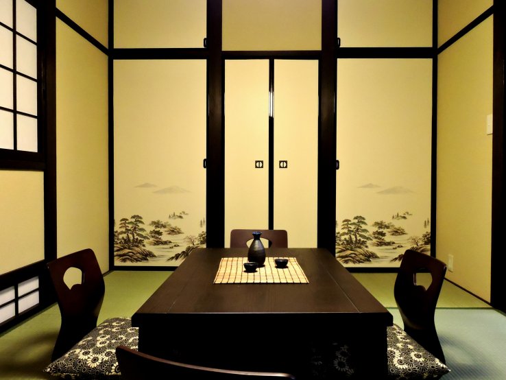 <p>I loved the illustrations of pines and rocks on the doors in the living room. This low table is the kotatsu, but sadly I didn't get a photo of it after the kotatsu blanket was added.</p>