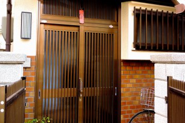 <p>The unassuming front door of the vacation rental, with a bicycle parked outside</p>